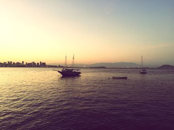 Boat sailing in sea at sunset