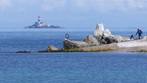 Scenic view of sea by buildings against sky