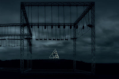 Low angle view of silhouette electricity pylon against sky