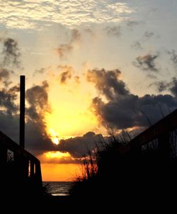 Scenic view of sea against cloudy sky during sunset