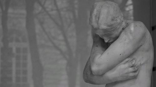 Midsection of woman with statue against blurred background