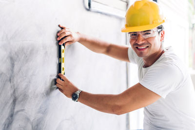 Portrait of man working on wall