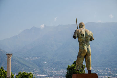 Statue on mountain against sky