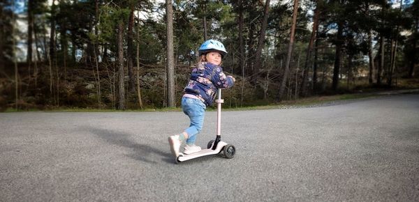 Portrait of boy skateboarding on road
