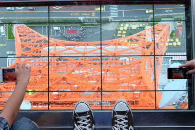 People photographing metallic structure from tall building