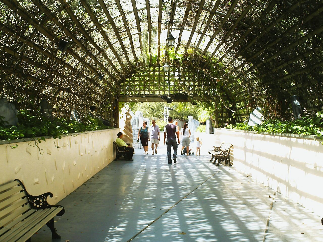 indoors, lifestyles, men, walking, person, architecture, leisure activity, full length, built structure, tunnel, arch, rear view, the way forward, togetherness, reflection, water, wall - building feature, medium group of people