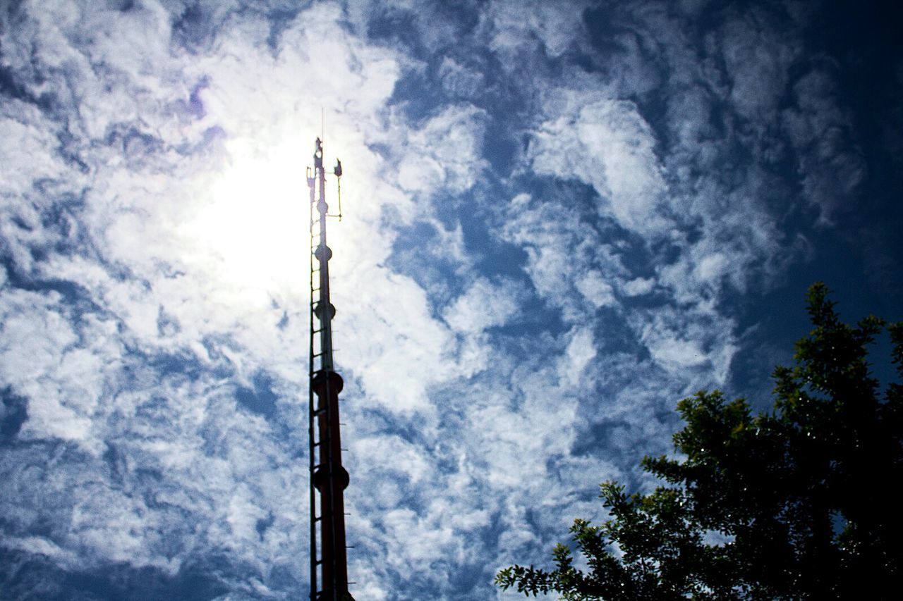 low angle view, sky, communication, cloud - sky, tower, no people, outdoors, broadcasting, built structure, technology, antenna - aerial, tree, day, nature, architecture