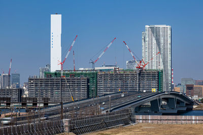 Modern bridge in city against clear sky