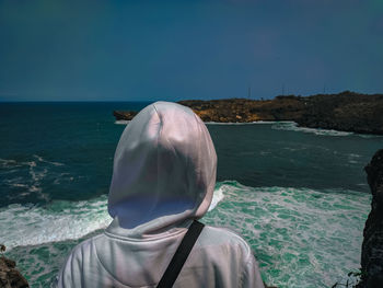 Rear view of woman looking at sea against sky