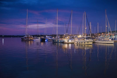 Sailboats in marina at harbor against sky