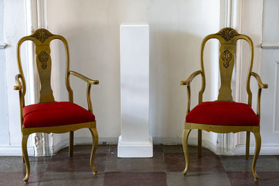 Empty chairs on table against wall at home