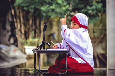 Side view of a boy holding camera