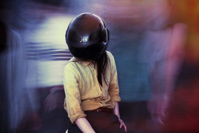 Rear view of a woman standing against blurred background