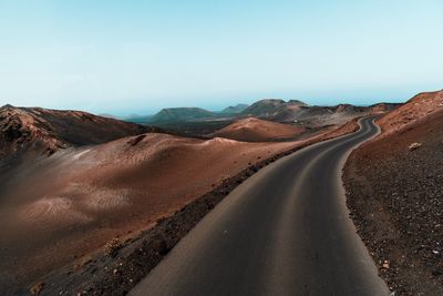 Empty road in desert against clear sky