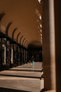 Rear view of man walking in tunnel