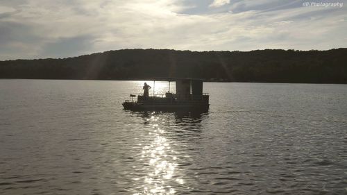 Silhouette boat sailing on sea against sky