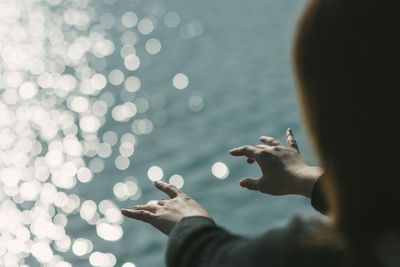 Cropped image on girl playing air piano against sea