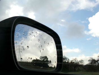 Reflection of clouds in side-view mirror