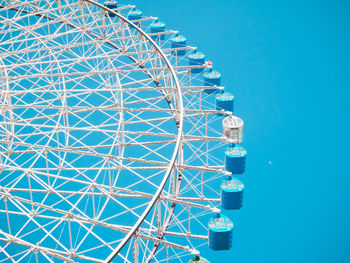 Low angle view of ferris wheel against blue sky