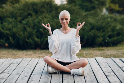 Woman meditating while sitting outdoors