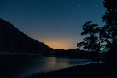 Scenic view of lake against sky at night