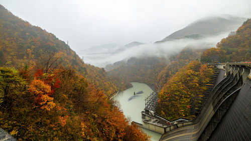 Electric power dam in middle of a valley with fog rain in autumn season japan