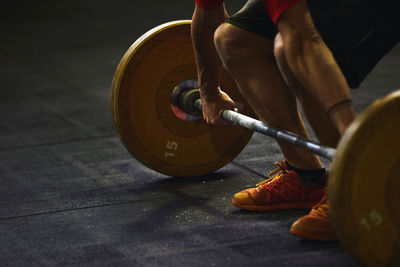 Low section of person with umbrella standing on wood
