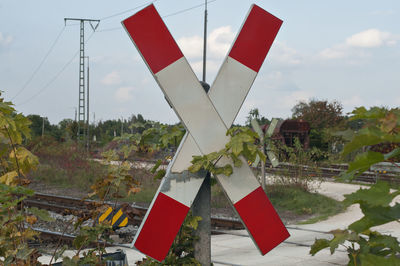 Red flags hanging on landscape against sky