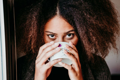 Close-up portrait of young woman drinking coffee