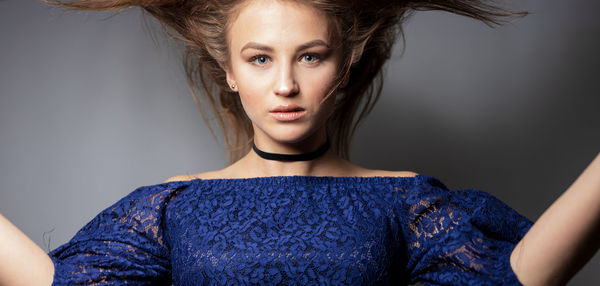 Portrait of young woman against gray background