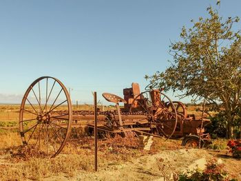 Abandoned cart on field against sky