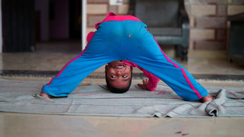  little indian boy doing yoga exercise and watching instructions on tv.. worldwide yoga day concept.