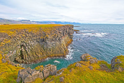 Steep cliffs on a colorful sea shore near arnarstopi, iceland