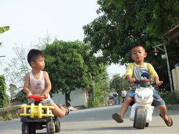 Portrait of siblings sitting on street