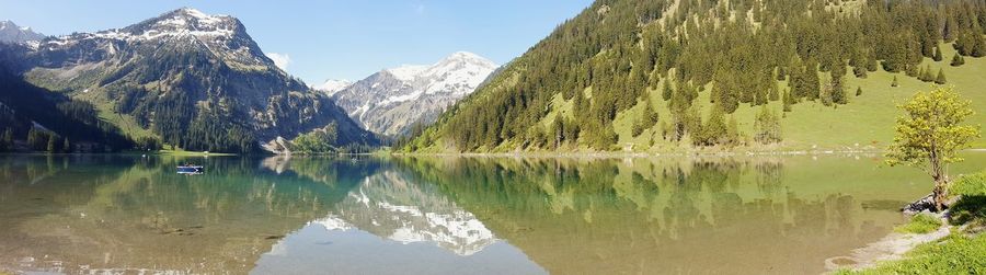 Scenic view of lake and mountains against clear sky