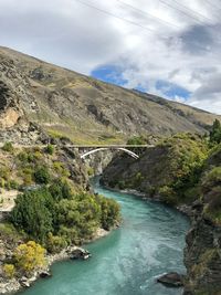 Scenic view of river amidst mountains against sky