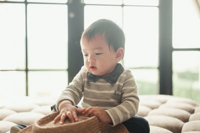 Cute boy looking away while sitting at home