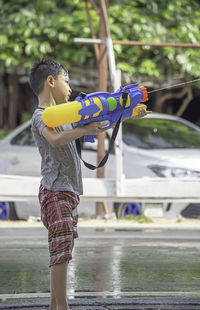 Boy playing with squirt gun outdoors