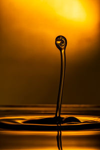 Close-up of water drop on orange sunset