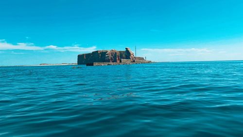 Scenic view of sea against blue sky