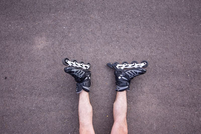 Low section of man with roller skates on road