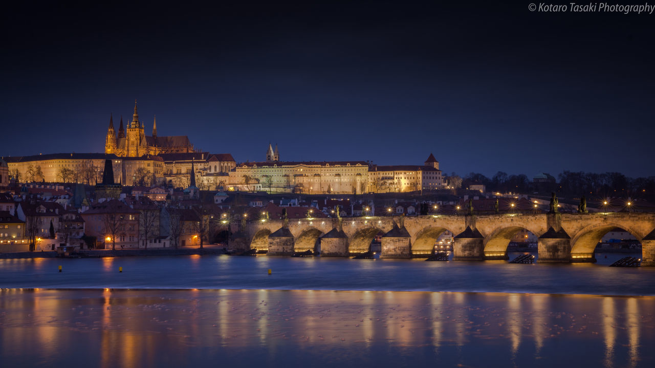 REFLECTION OF ILLUMINATED BUILDINGS IN WATER AT NIGHT