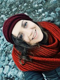 High angle portrait of woman wearing scarf standing on stones during winter