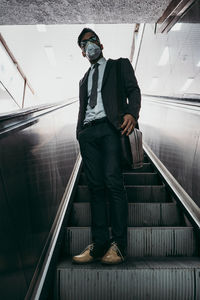 Business man standing on city street with protective face mask.