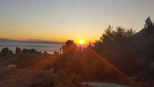 Scenic view of silhouette mountains against clear sky during sunset