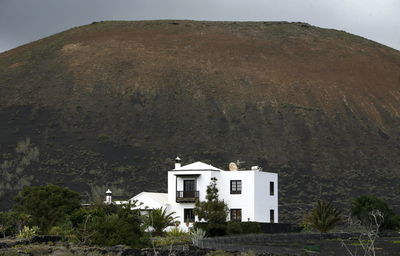 Whitewashed building against mountain