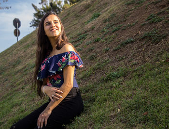 Tilt shot of smiling young woman on field