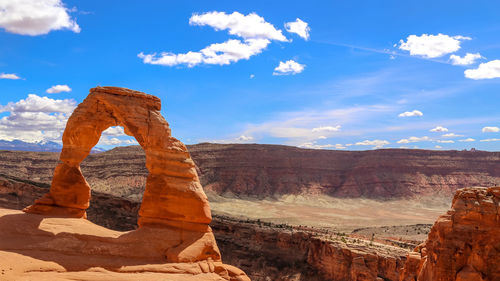 Rock formations on landscape against cloudy sky