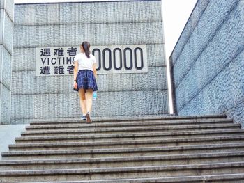 Rear view of woman walking on staircase