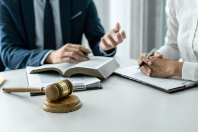 Midsection of lawyer working at desk in office